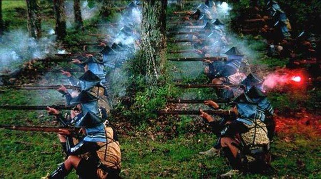 still from movie Ran, with soldiers firing guns